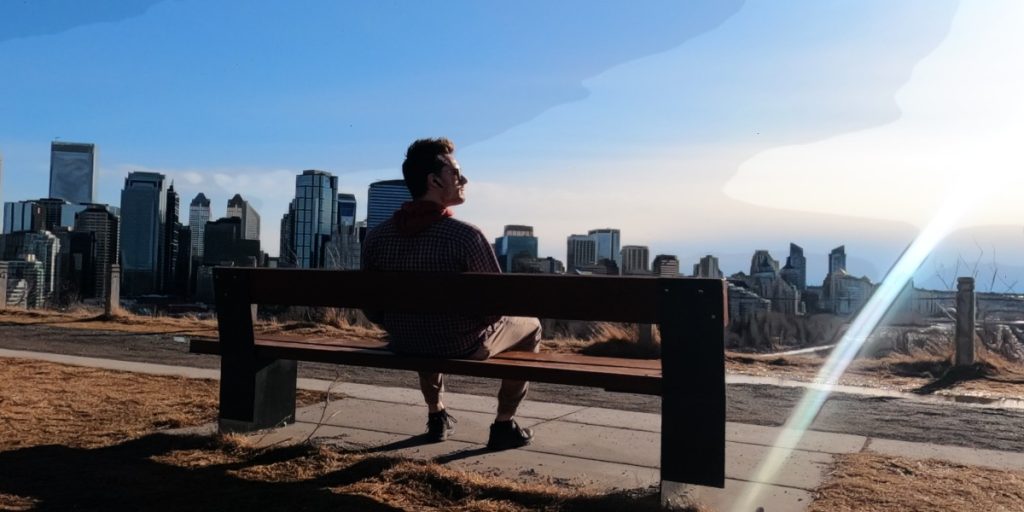 ScootyDub enjoying the sun on a bench overlooking downtown Calgary