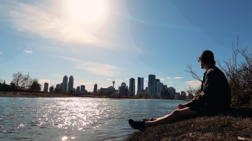 ScootyDub looking at the Calgary skyline sitting next to the Bow river