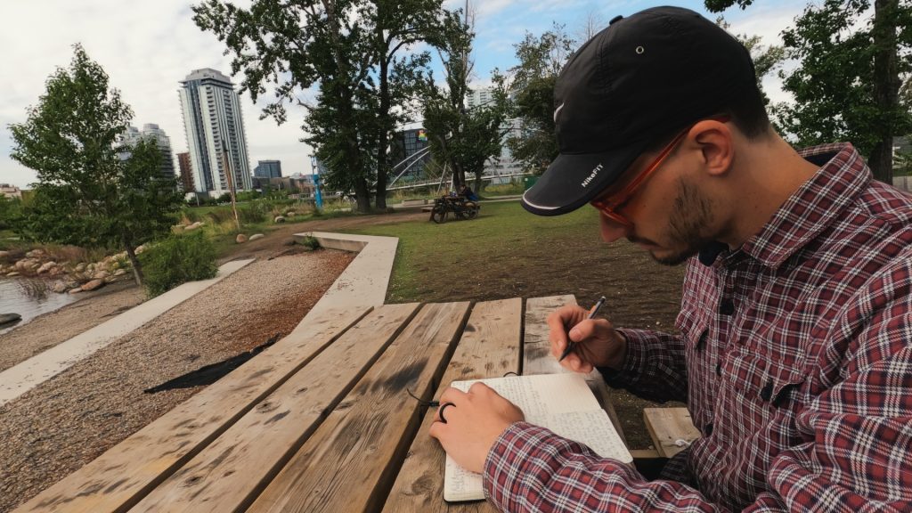 scootydub journaling on a picnic table near downtown Calgary