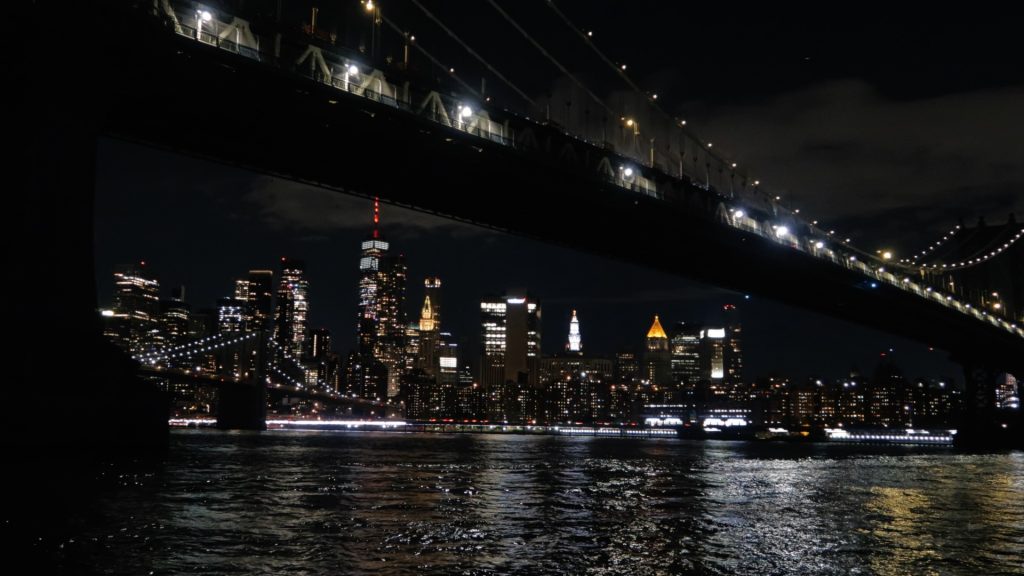 Manhattan skyline behind the Brooklyn Bridge at night