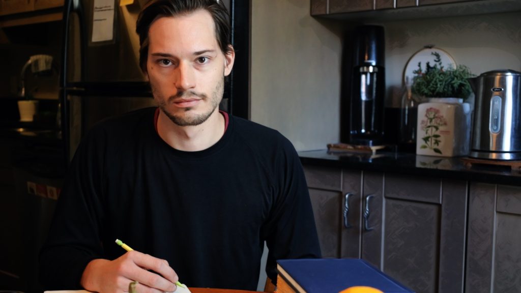 ScootyDub staring from across the table with a pencil in his hand