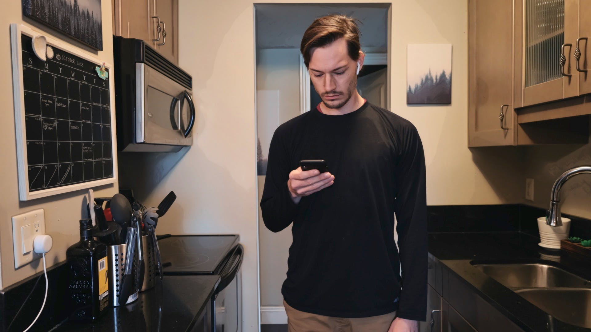 ScootyDub on his phone in the kitchen